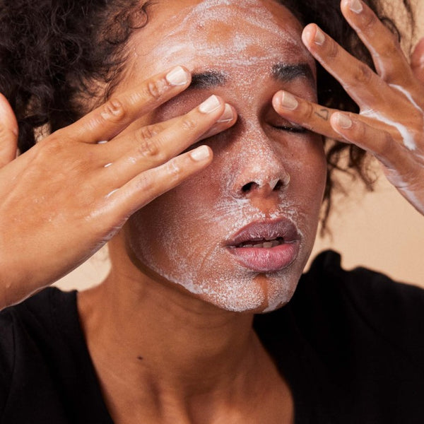 Model brengt Absolution Le Baume Céleste make-up remover balsem aan op haar gezicht