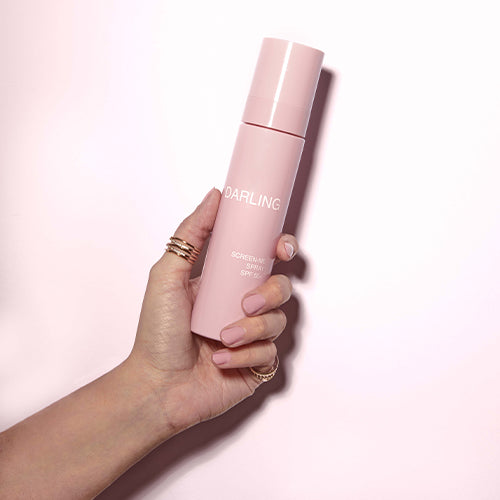 Model houdt Darling Screen-Me SPF 50 spray in de hand