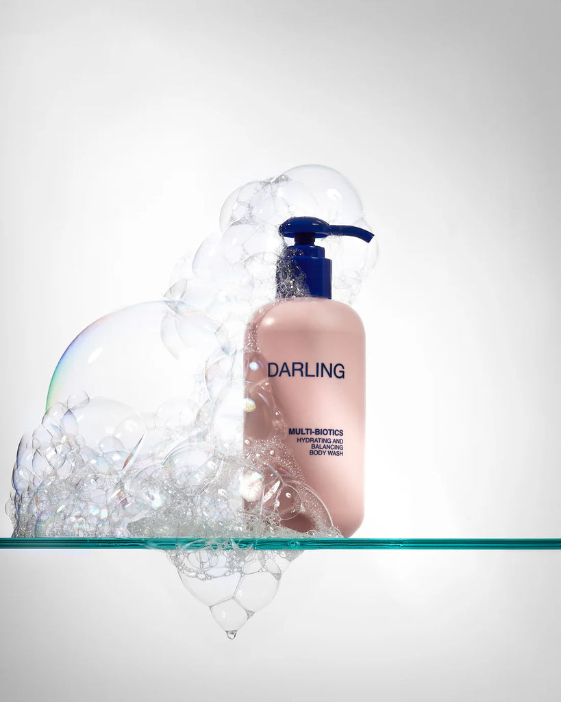 Darling Multi-Biotics Body Wash met schuimlaag op een glazen kast, luxe presentatie voor hydratatie en reiniging
