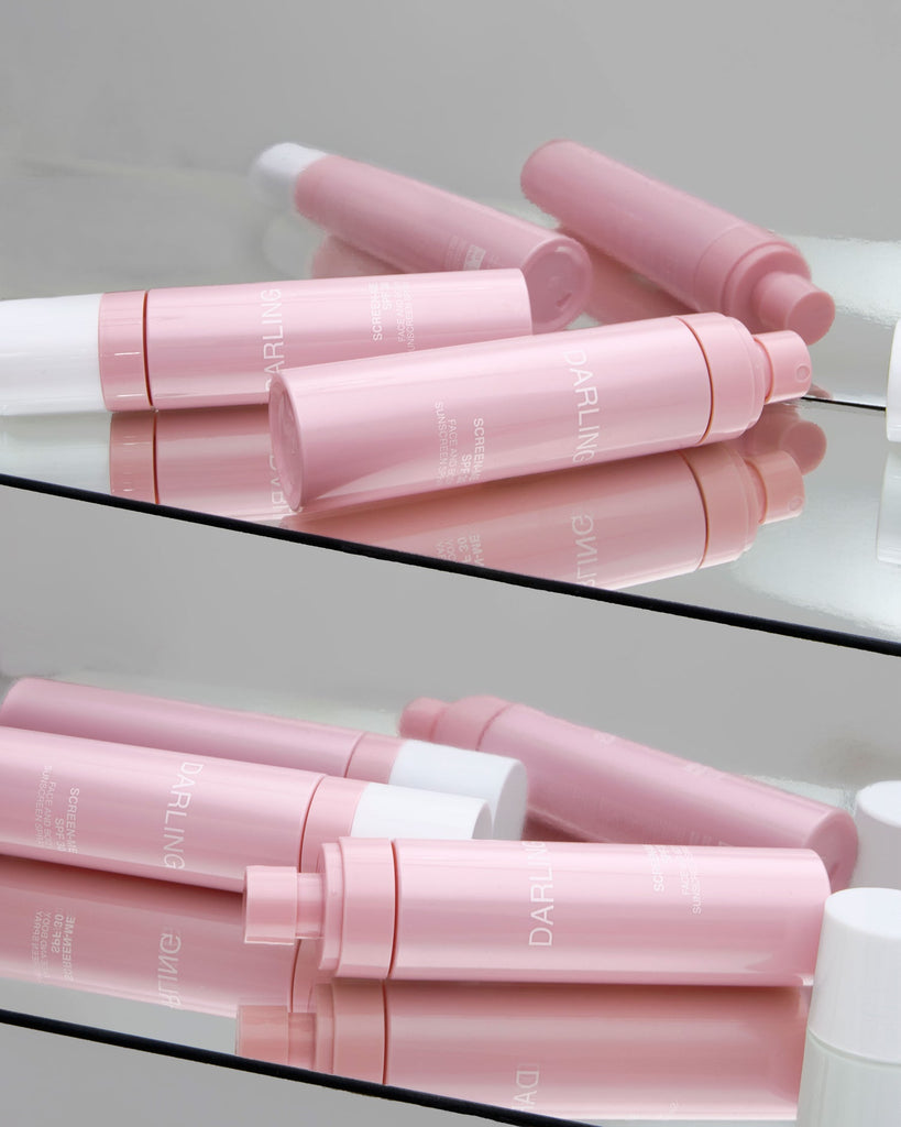 Vier Darling Screen-Me Spray SPF 30 flacons liggend in een stijlvolle spiegelkast