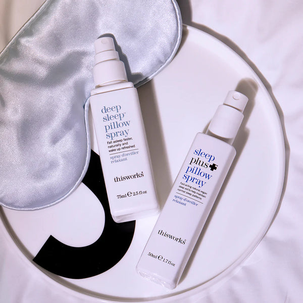 Lifestylefoto met This Works Sleep Plus+ Pillow Spray en Sleep Mist Spray op een schotel, samen met een oogmasker