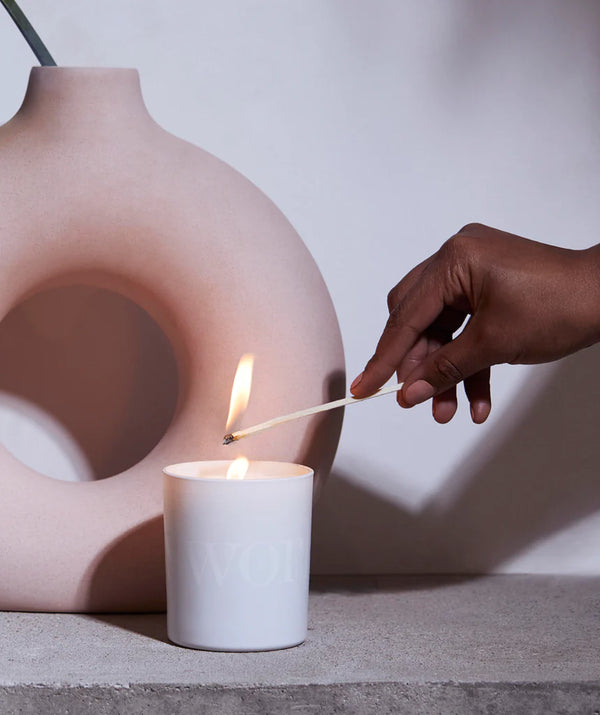 Sfeerbeeld van iemand die de Deep Sleep Heavenly Candle met een lucifer aansteekt