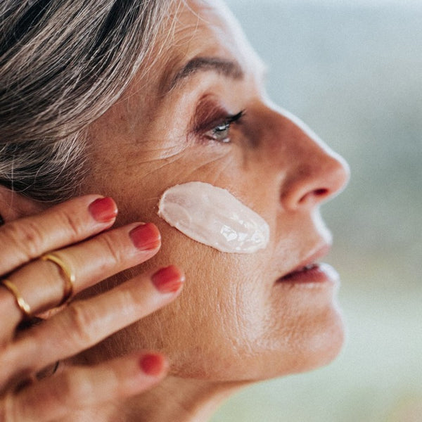 Iemand die Le Masque du Temps Redensifiant aanbrengt op haar gezicht