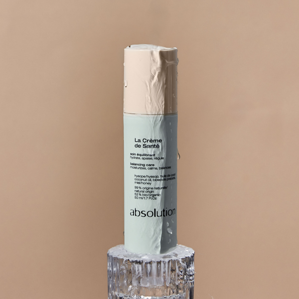 La Crème de Santé van Absolution Cosmetics geplaatst op een verhoging, benadrukt natuurlijke ingrediënten.