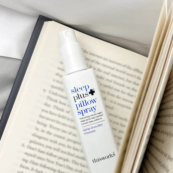 This Works Sleep Plus+ Pillow Spray 50 ml op een opengeslagen boek