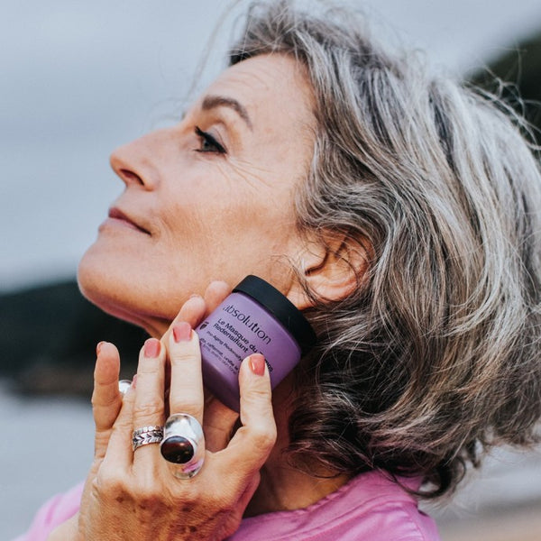 Vrouw houdt pot Le Masque du Temps tegen haar gezicht