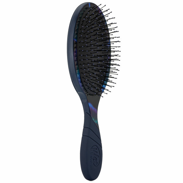 Close-up van de WetBrush Pro Detangler Rare Botanic in gebruik op nat haar, waarbij de flexibele borstelharen klitten en knopen verwijderen zonder pijn