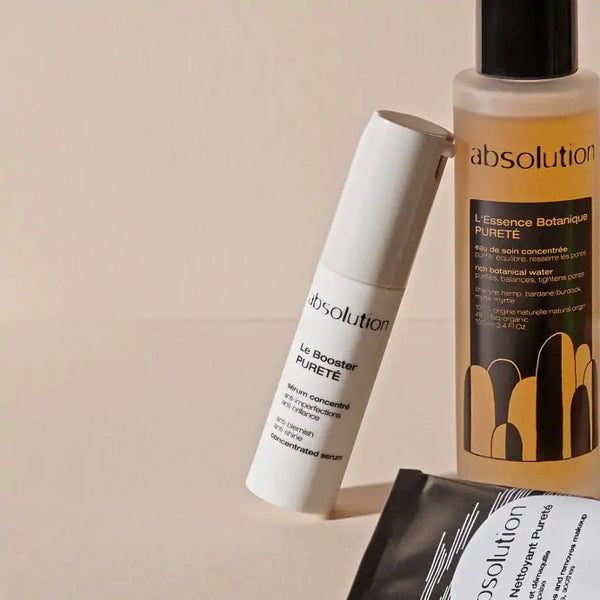 Sfeerfoto van Absolution Le Booster Pureté samen met andere Absolution-producten op een houten tafel