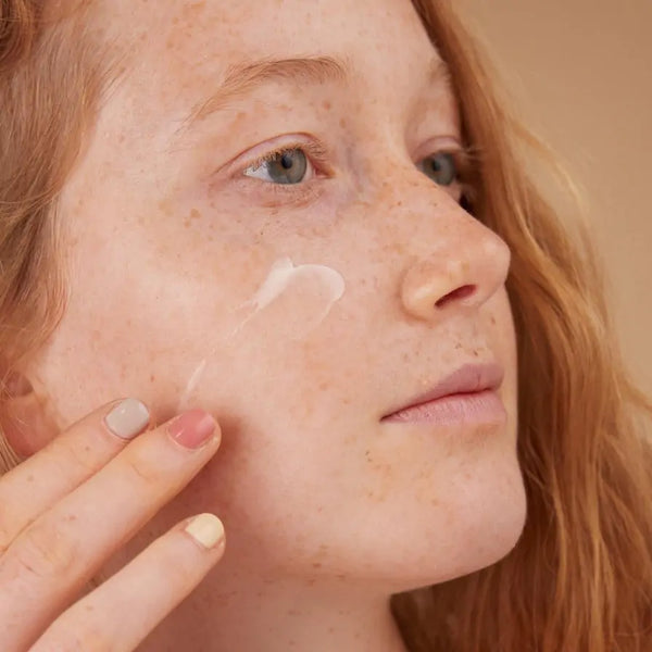 Meisje brengt La Crème de Santé aan op haar gezicht voor een gezonde uitstraling