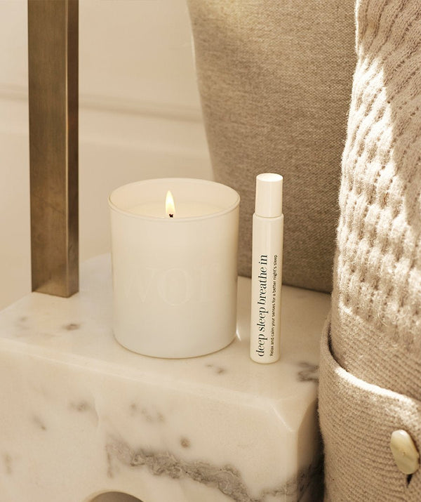 Sfeerbeeld vanThis Works  Deep Sleep Heavenly Candle op marmeren nachtkastje met Deep Sleep-producten ernaast