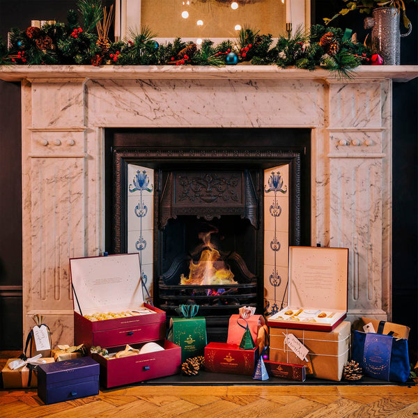 Sfeervolle foto van Aromatherapy Associates cadeaus op een feestelijk ingerichte schouw