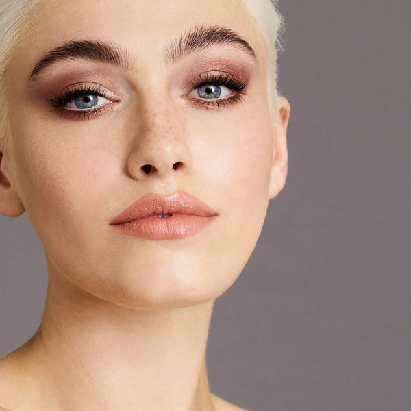 Close-up van een vrouw met make-up aangebracht met Delilah Smooth Shadow Sticks in de kleuren Hot Chocolate, Cinnamon Swirl en Pink Champagne