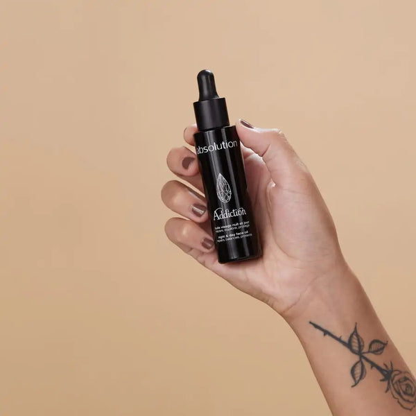 Iemand houdt Addiction, l’Huile Visage vast, een luxe gezichtsolie voor elke huid.