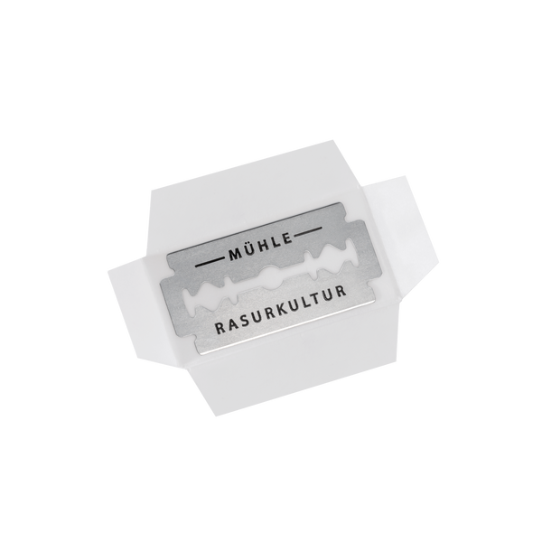 Open verpakking van Mühle scheermesjes met een zichtbaar roestvrijstalen mesje waarop 'Mühle Rasurkultur' staat